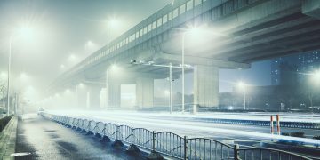 An image of an abandoned city road illuminated by street lights on a cold night in Shanghai, China, illustrating the impact of the Coronavirus.